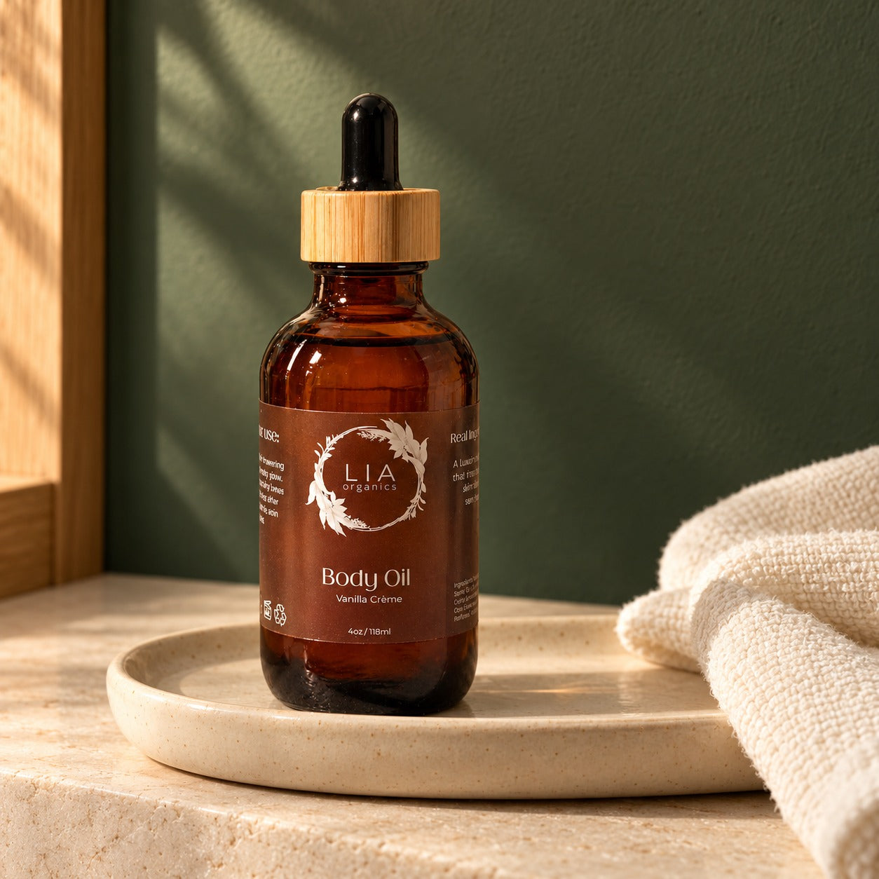Full-size Lia Organics Body Oil bottle on a tray against a forest-green wall